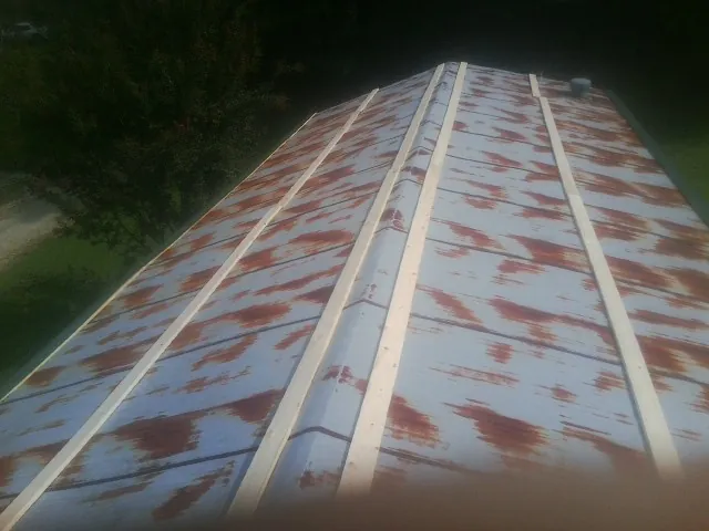 Rusted metal roof panels with new wood purlins before replacement — Storm Damage Roof Repair in Elbert by Roofing Brothers