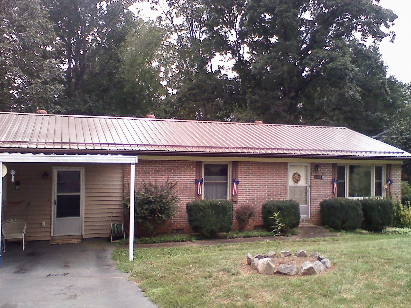 Bronze metal roof and carport on a brick ranch home — Roof Repair work by our crew in Elbert